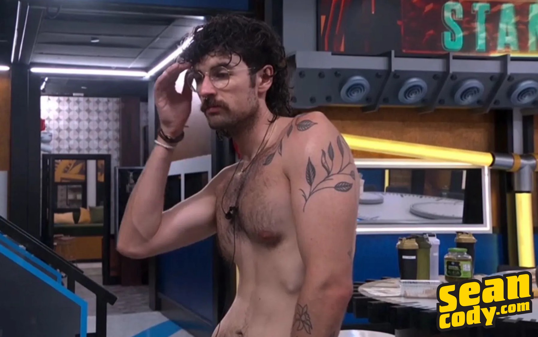 Barrett, shirtless in the BB28 kitchen with the SeanCody logo in the lower right corner added