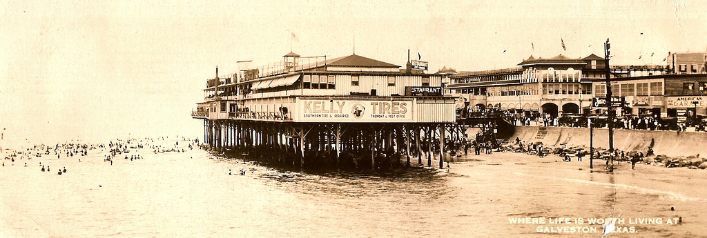 Historic panoramic postcard view of Murdoch’s Pier and the beach along Galveston’s Seawall
