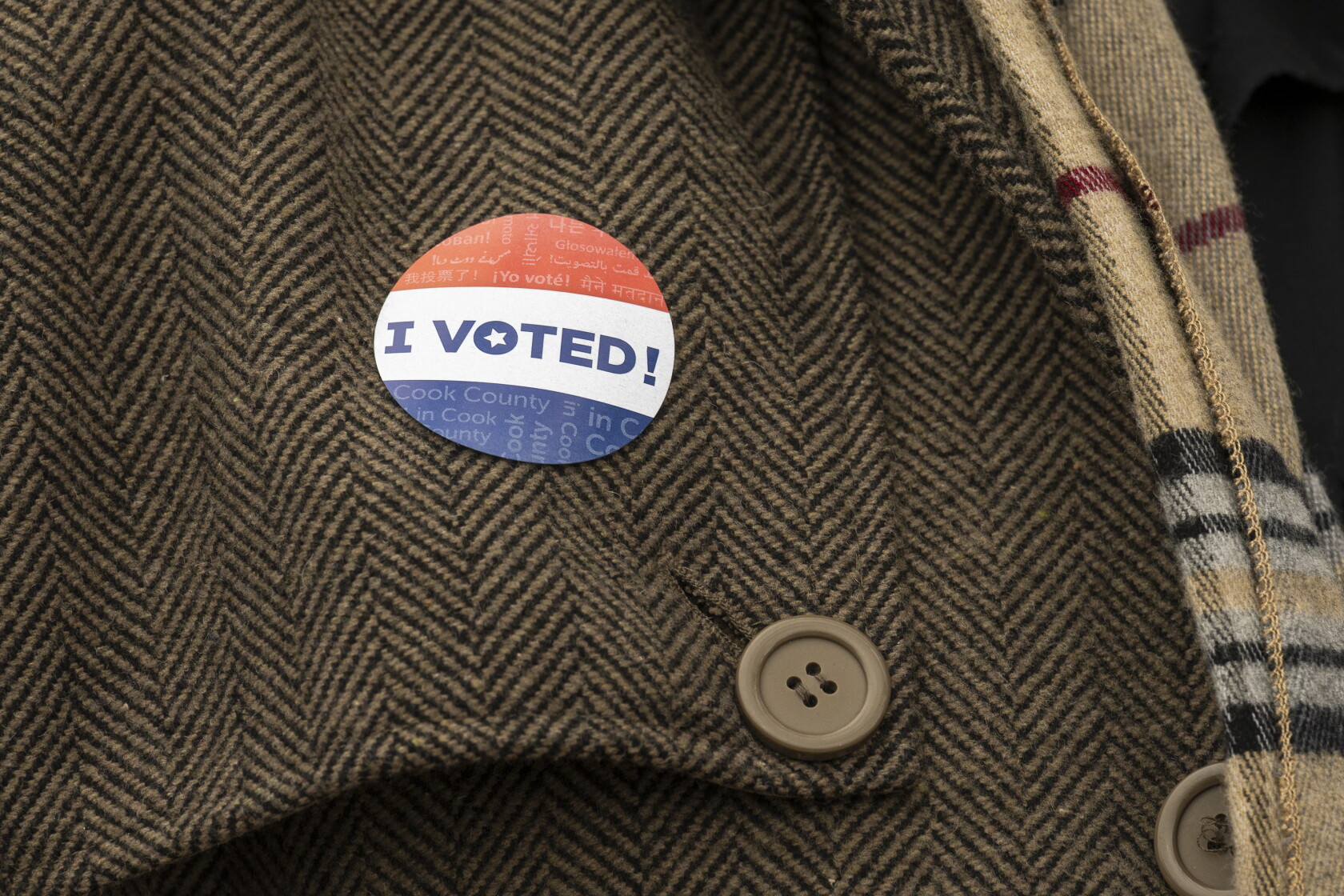 Red, white, and blue I Voted sticker on a coat