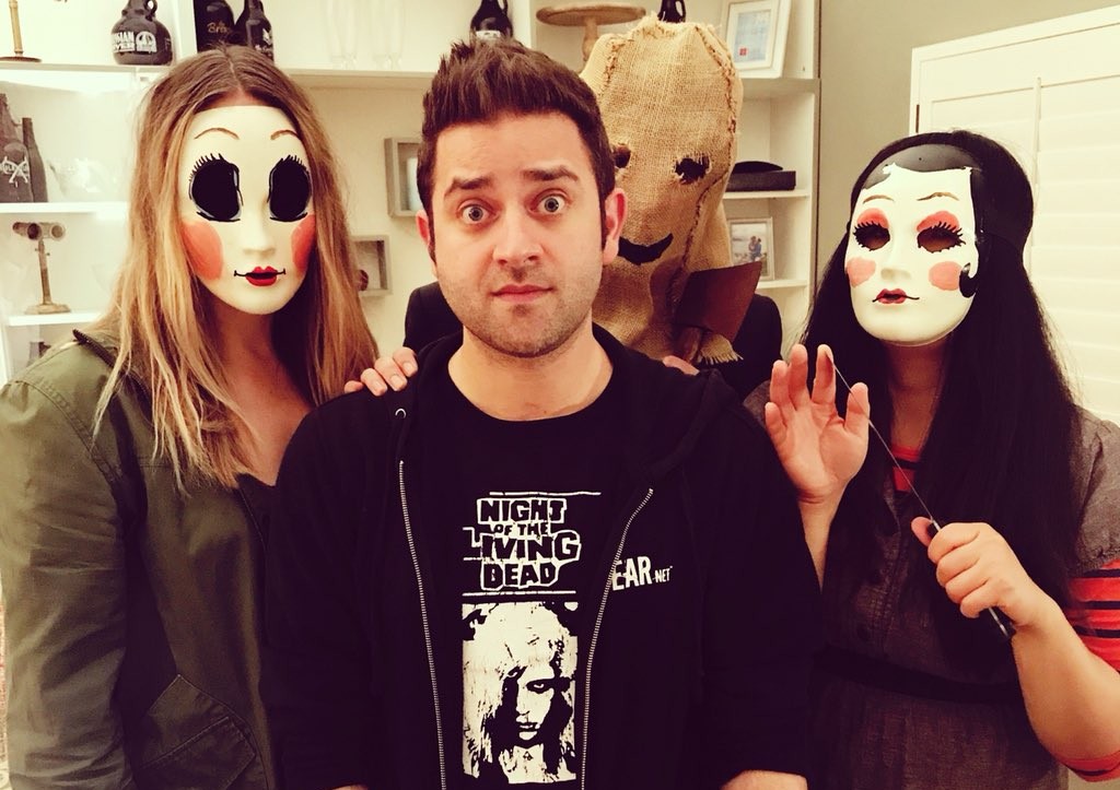 Michael Varrati standing with three masked performers on a film set.